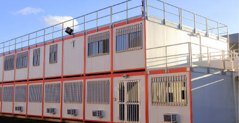 Extension modulaire - Algéco - Container Bâtiment modulaire à plusieurs étages avec balustrade, fenêtres et climatiseurs.