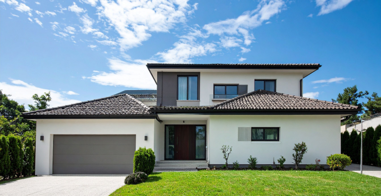 Maison de plain-pied avec façade en briques, garage et jardin soigné.