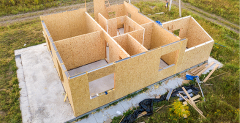 Construction d'une maison en bois, murs intérieurs partiellement érigés.